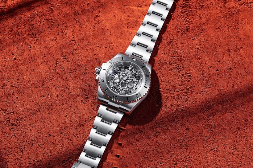 A silver watch on a red background