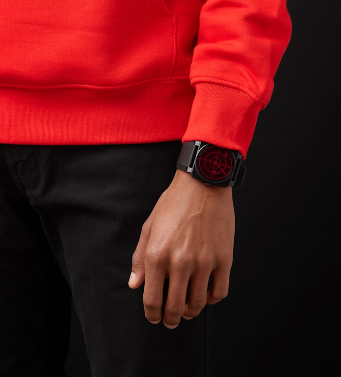 A person in a red sweatshirt wearing a Bell-Ross watch