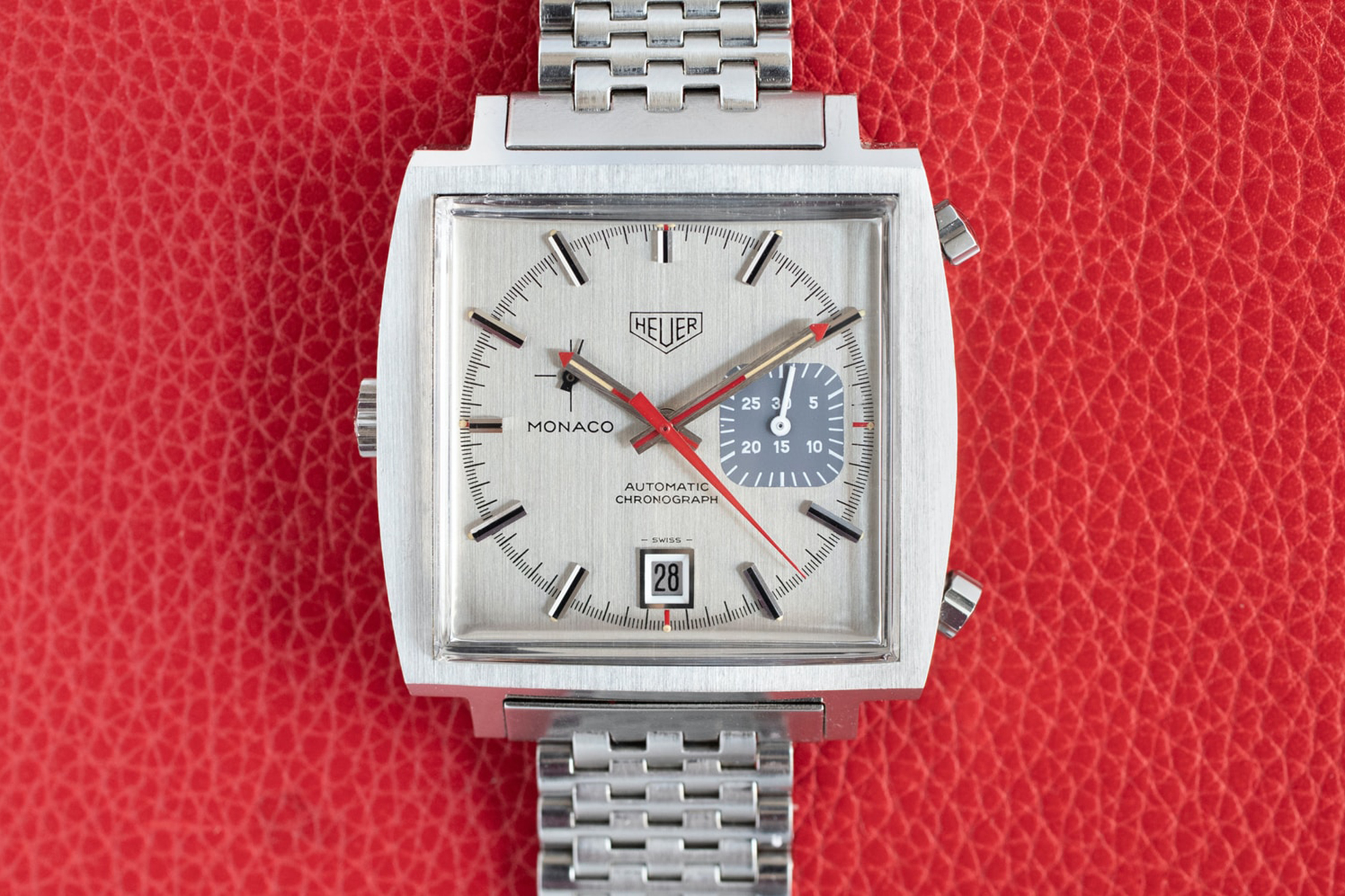 A Caliber 15 Monaco watch on a red background 