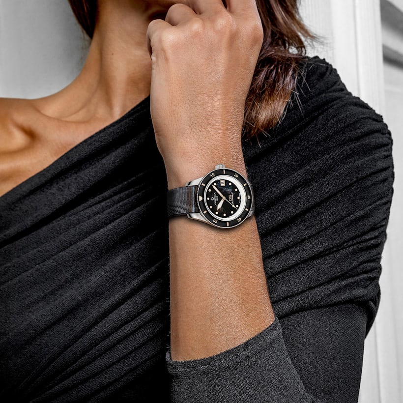 A woman in a black shirt wearing a Certina watch