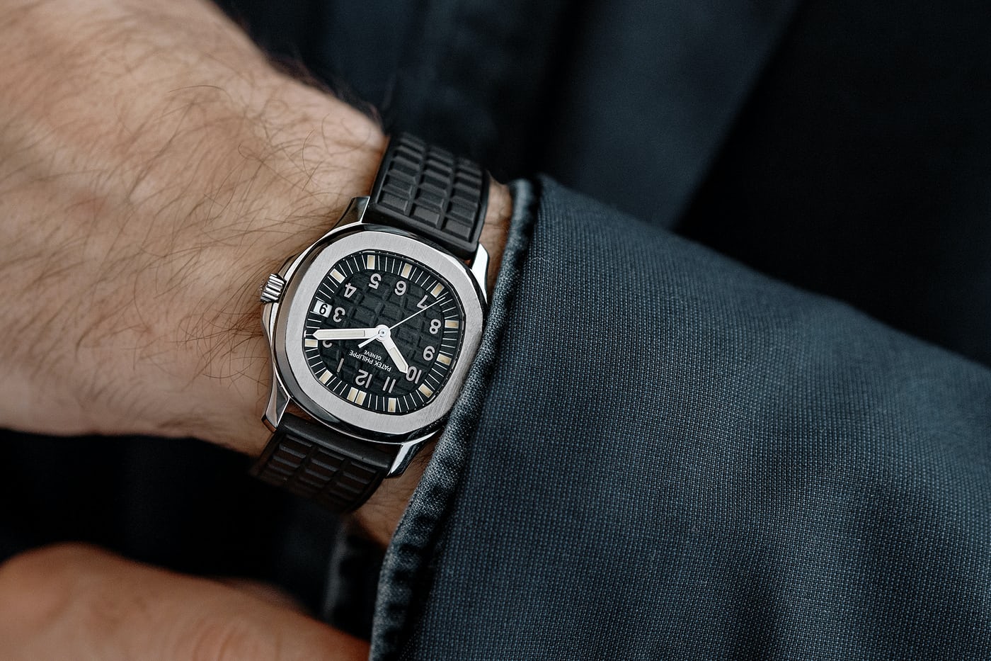 The Patek Philippe Aquanaut 5060A wrist shot with a blazer and denim shirt