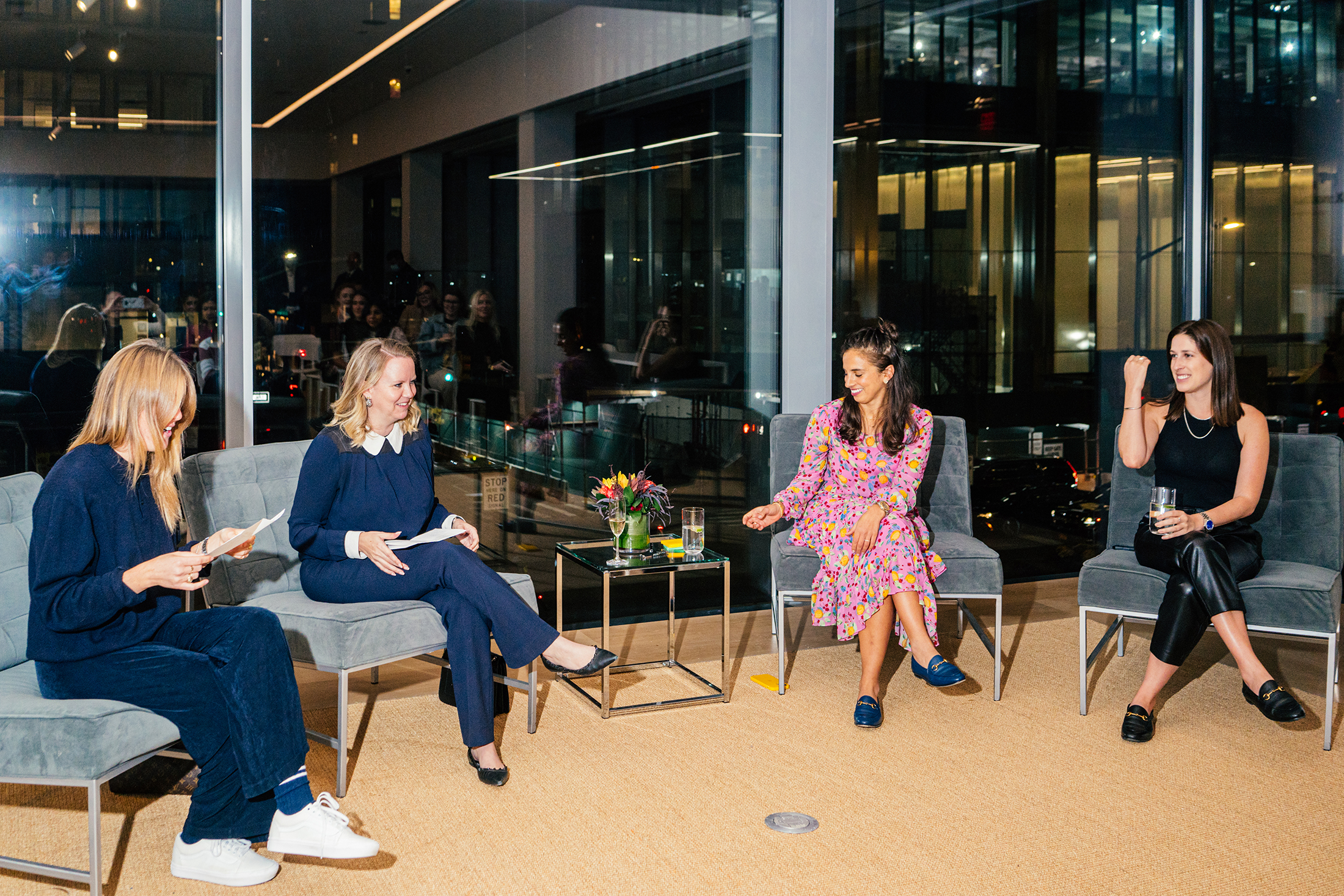 Four women on a panel in front of a window