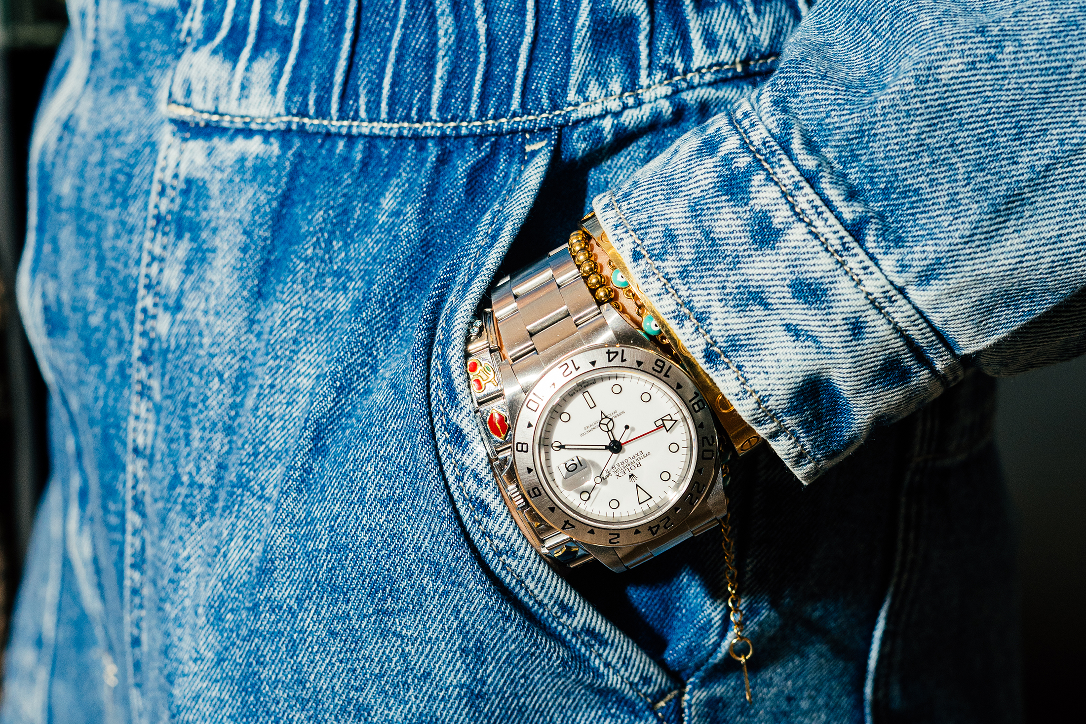 A watch on a wrist with thin bracelets