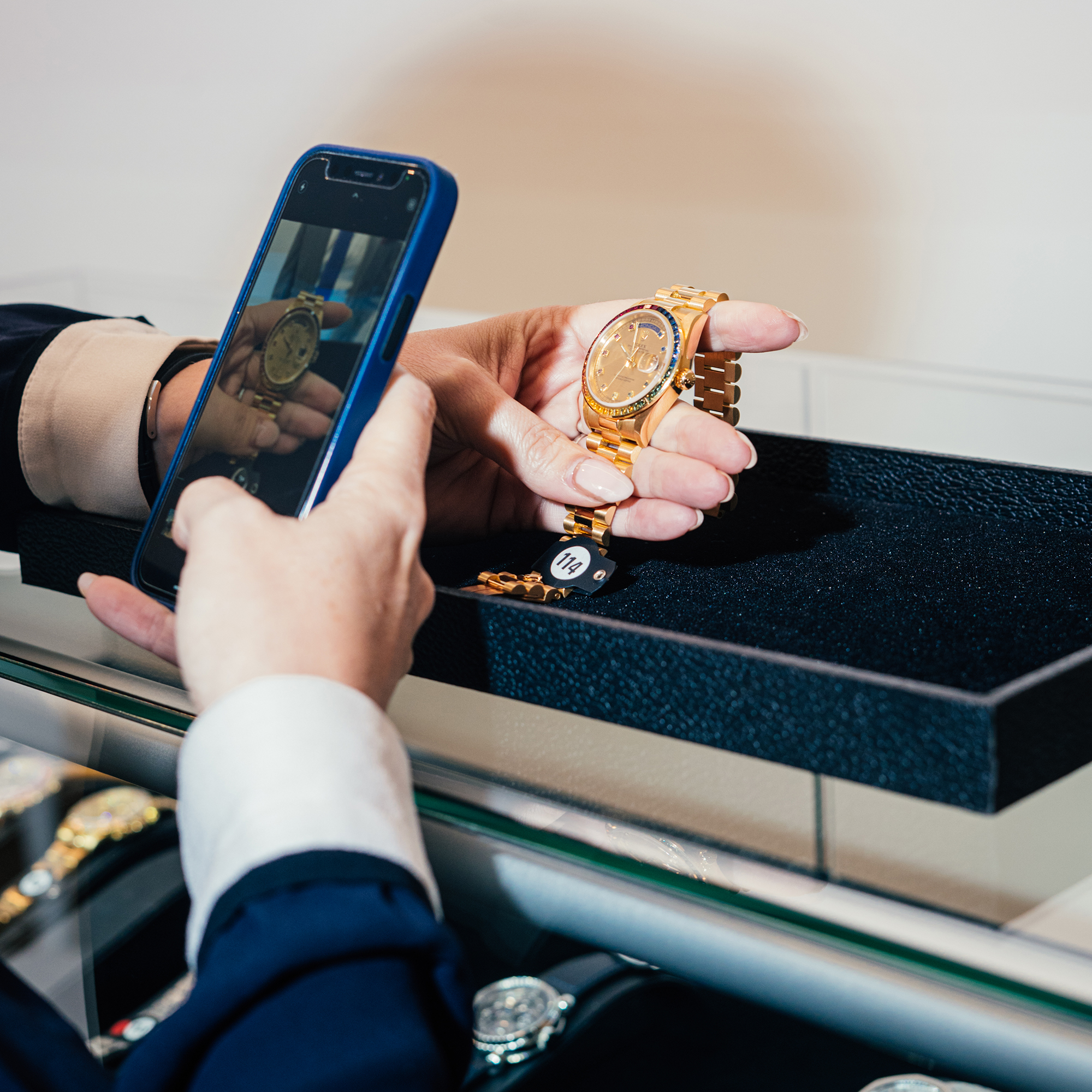 Someone taking a photo of a watch on a phone