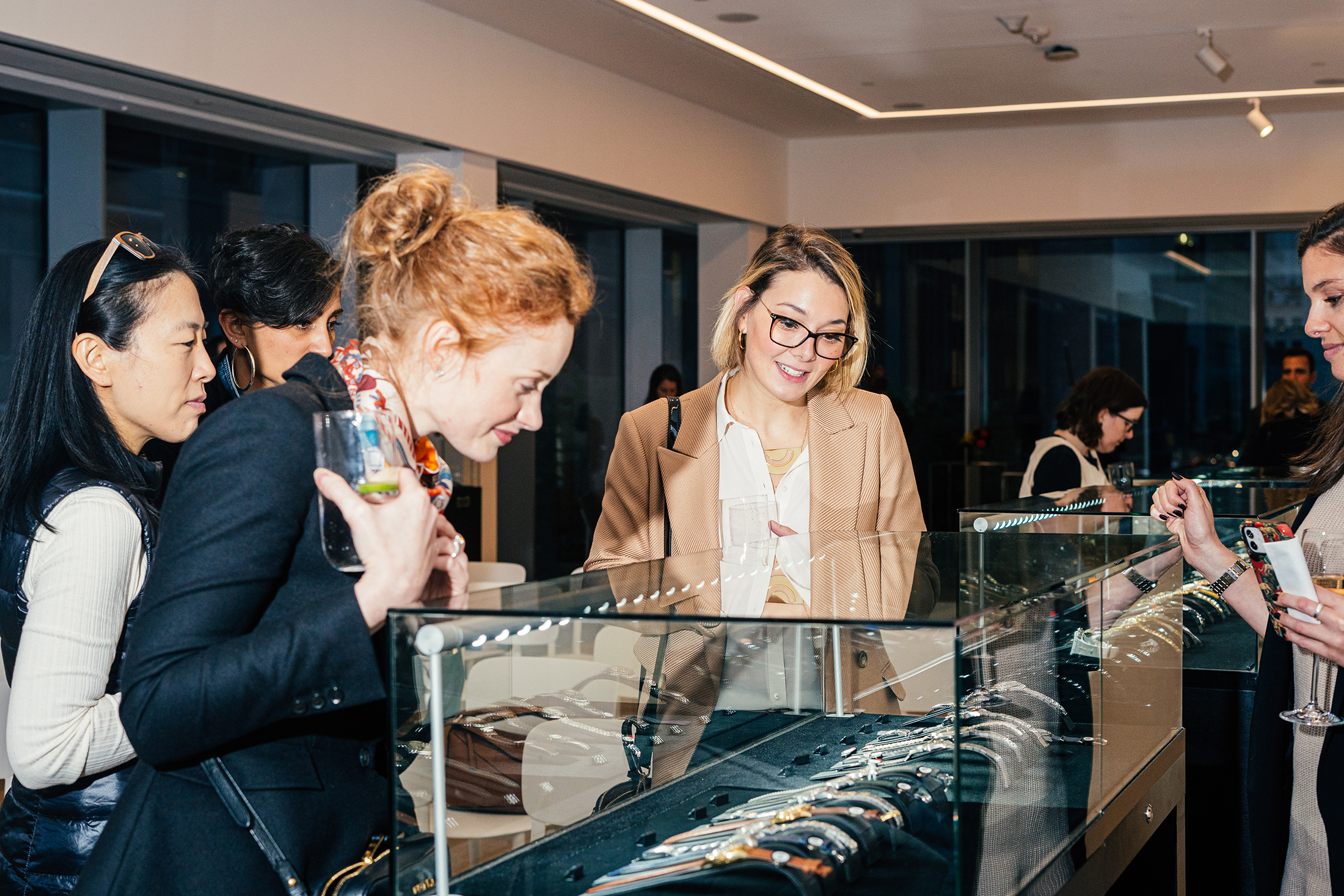 People looking at watches in a case