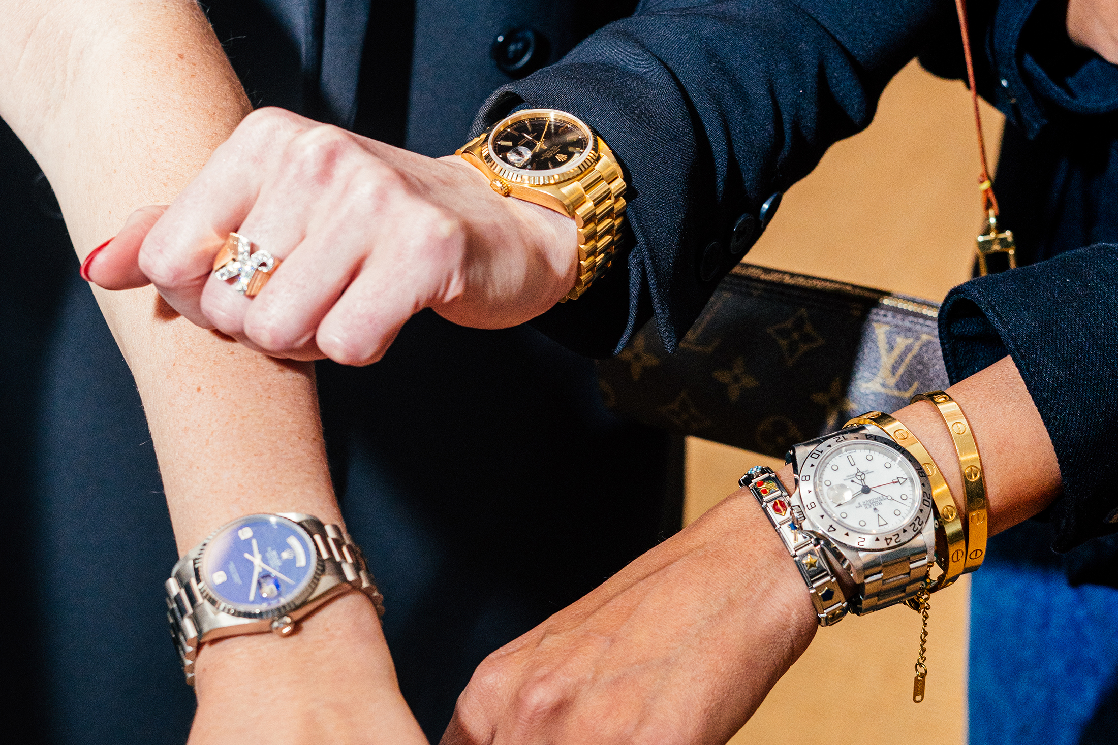 Three wrists with watches on them