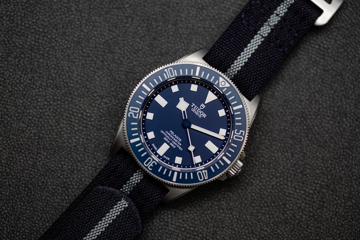 The Pelagos FXD laying on a table with a fabric strap. 