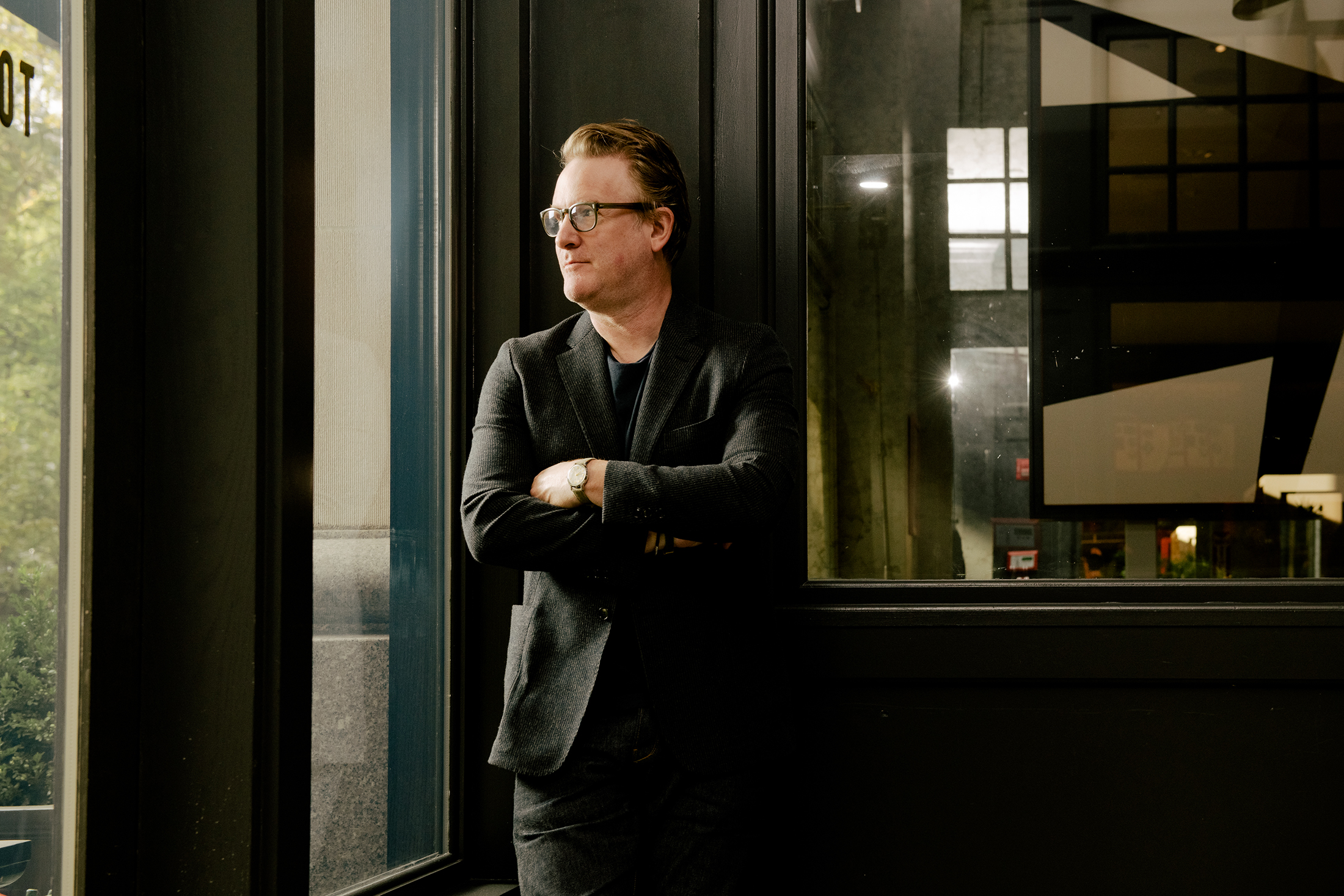 A man poses by a window