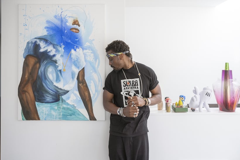 Ini Archibong poses in front of a Khari Turner painting