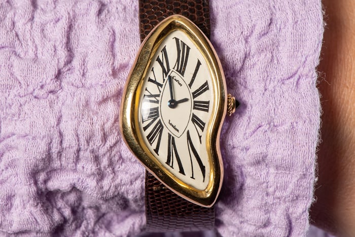 A Cartier crash watch on purple fabric 