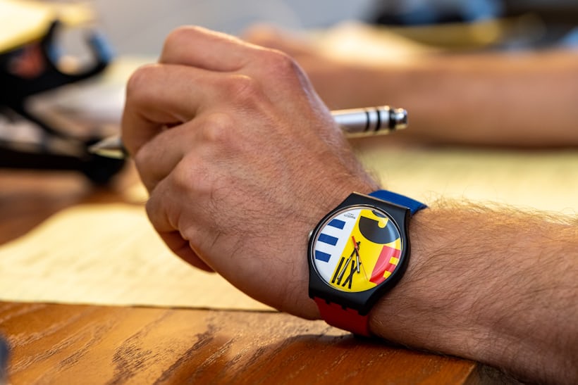 A Swatch watch on a wrist