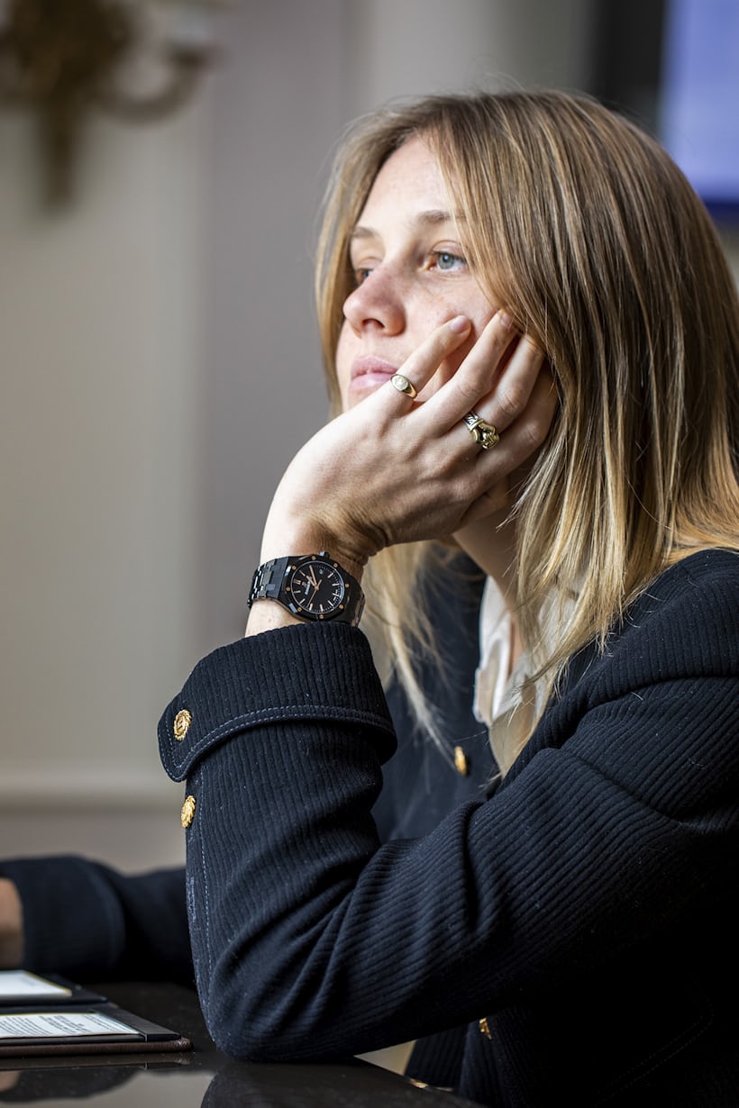 A woman in thought, with a Royal Oak watch on her wrist