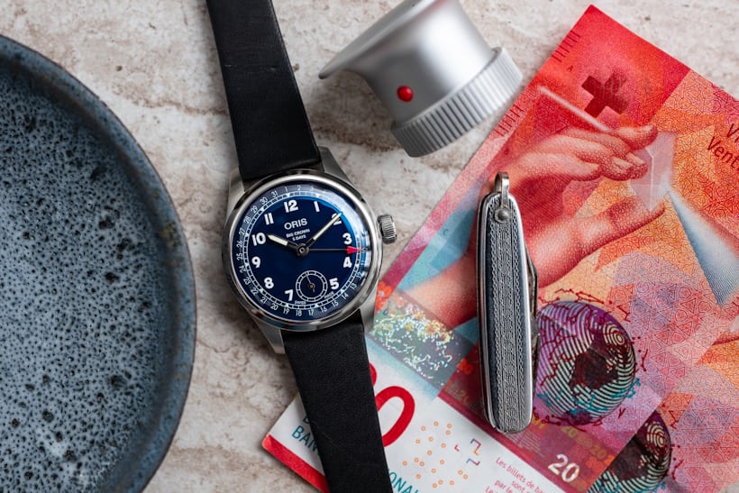 An Oris BC 403 on a table with money and other accessories