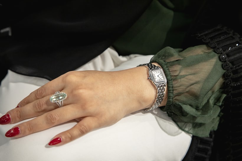 a person with red nails and a Cartier watch