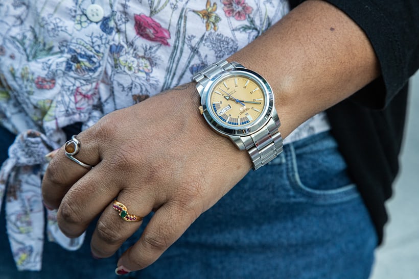 A person wearing a Seiko watch and rings