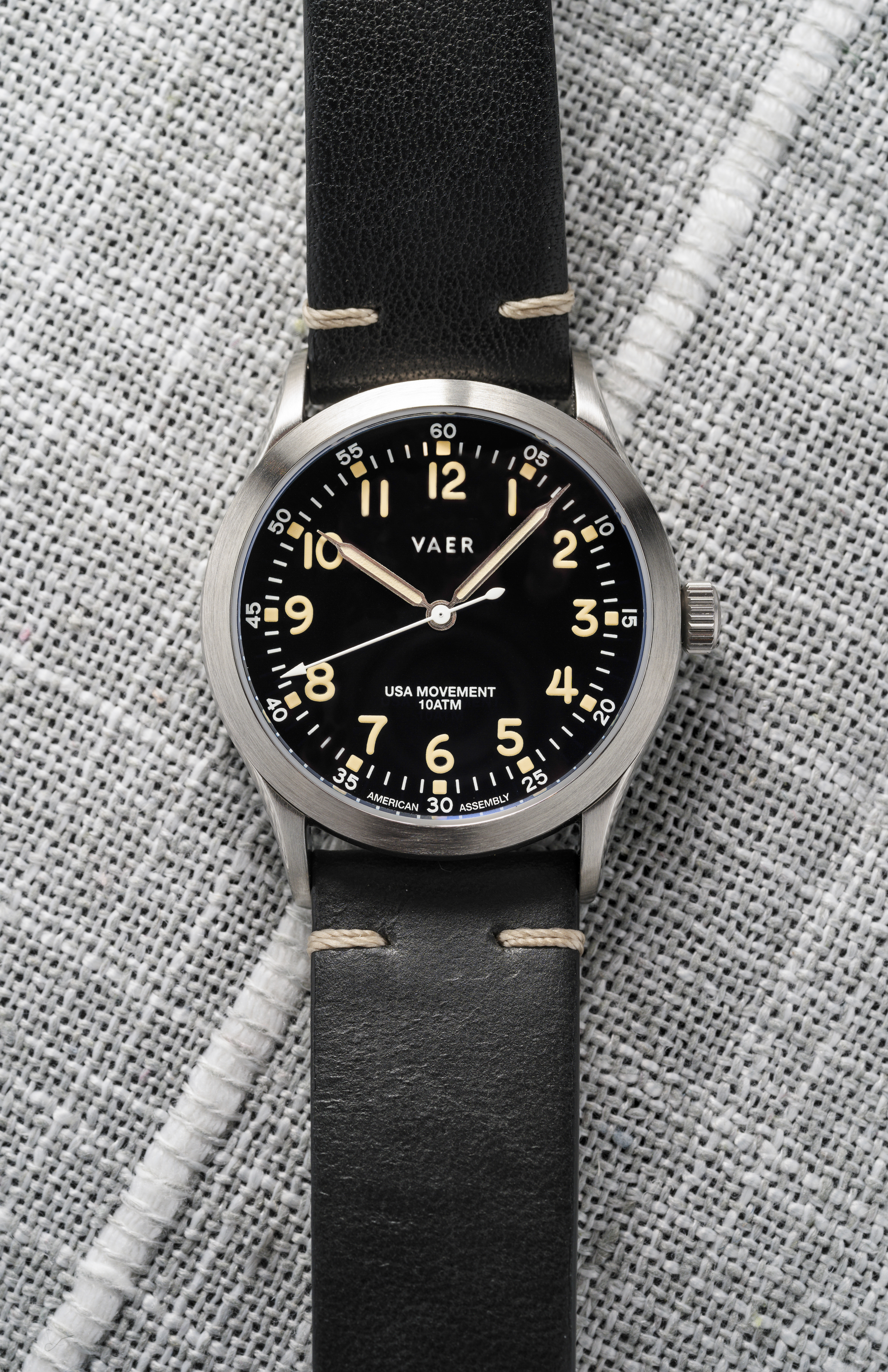 A black dial field watch on a leather strap.
