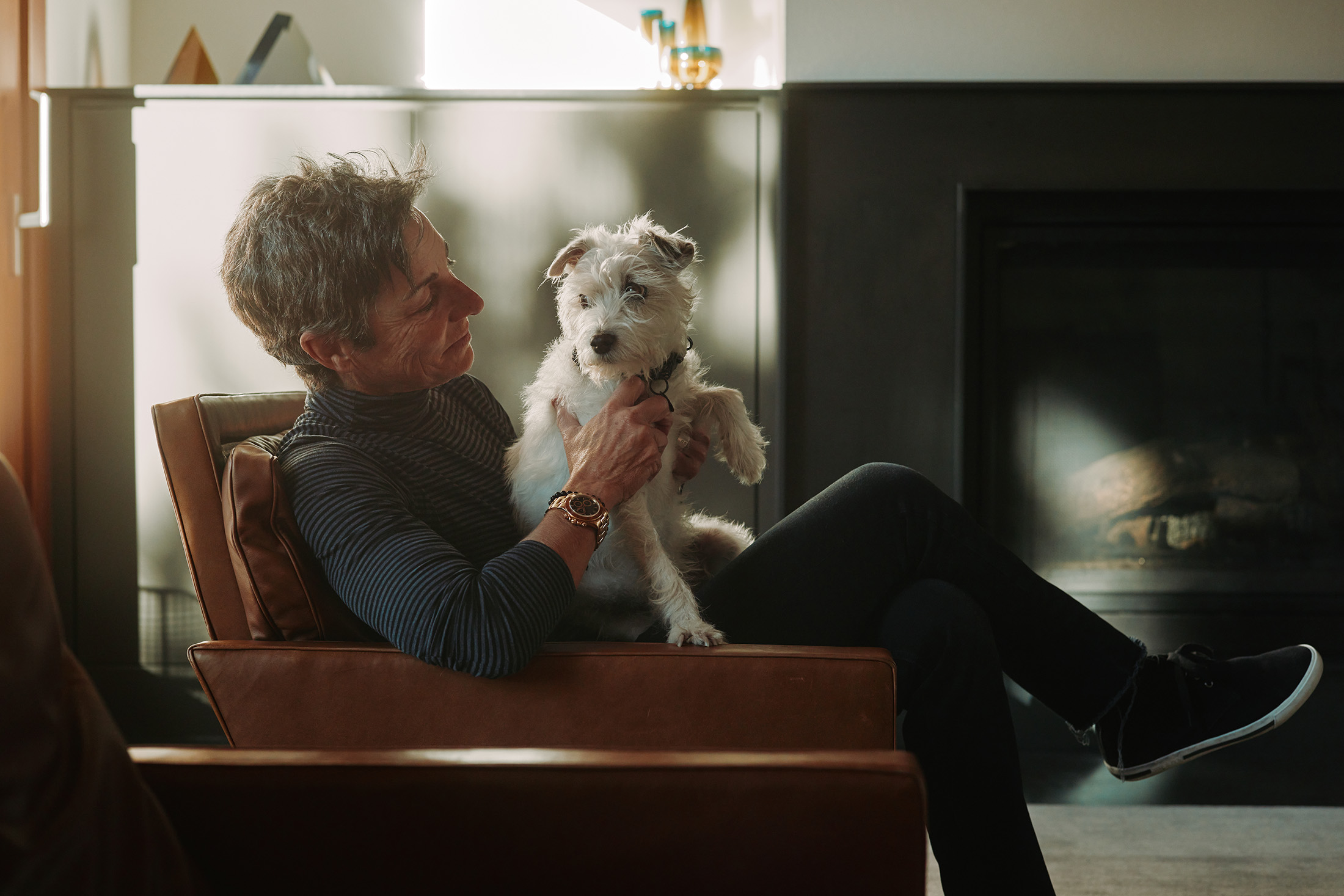 A woman poses with a white dog and a Rolex watch