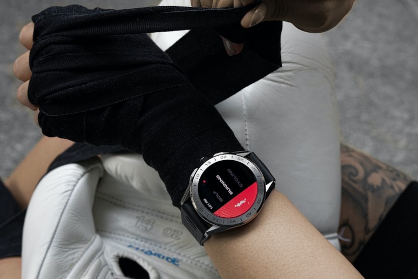 A woman ties her hands up as she prepares for a boxing class with a TAG Heuer Connected on her wrist.