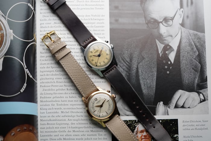 Two watches laid over a newspaper article