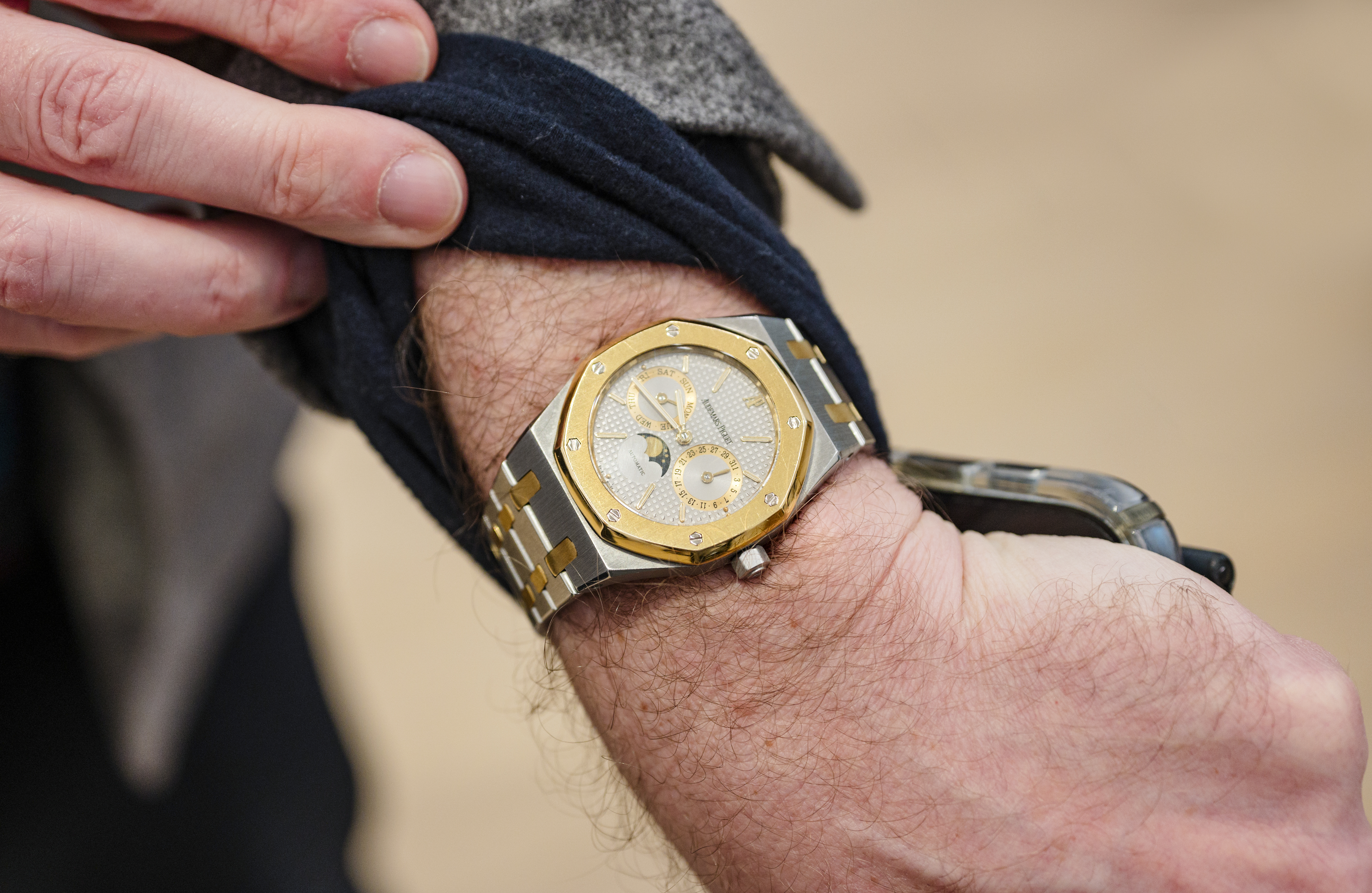 A man wears an Audemars Piguet Royal Oak Perpetual Calendar Two Tone and holds his sleeve up. 