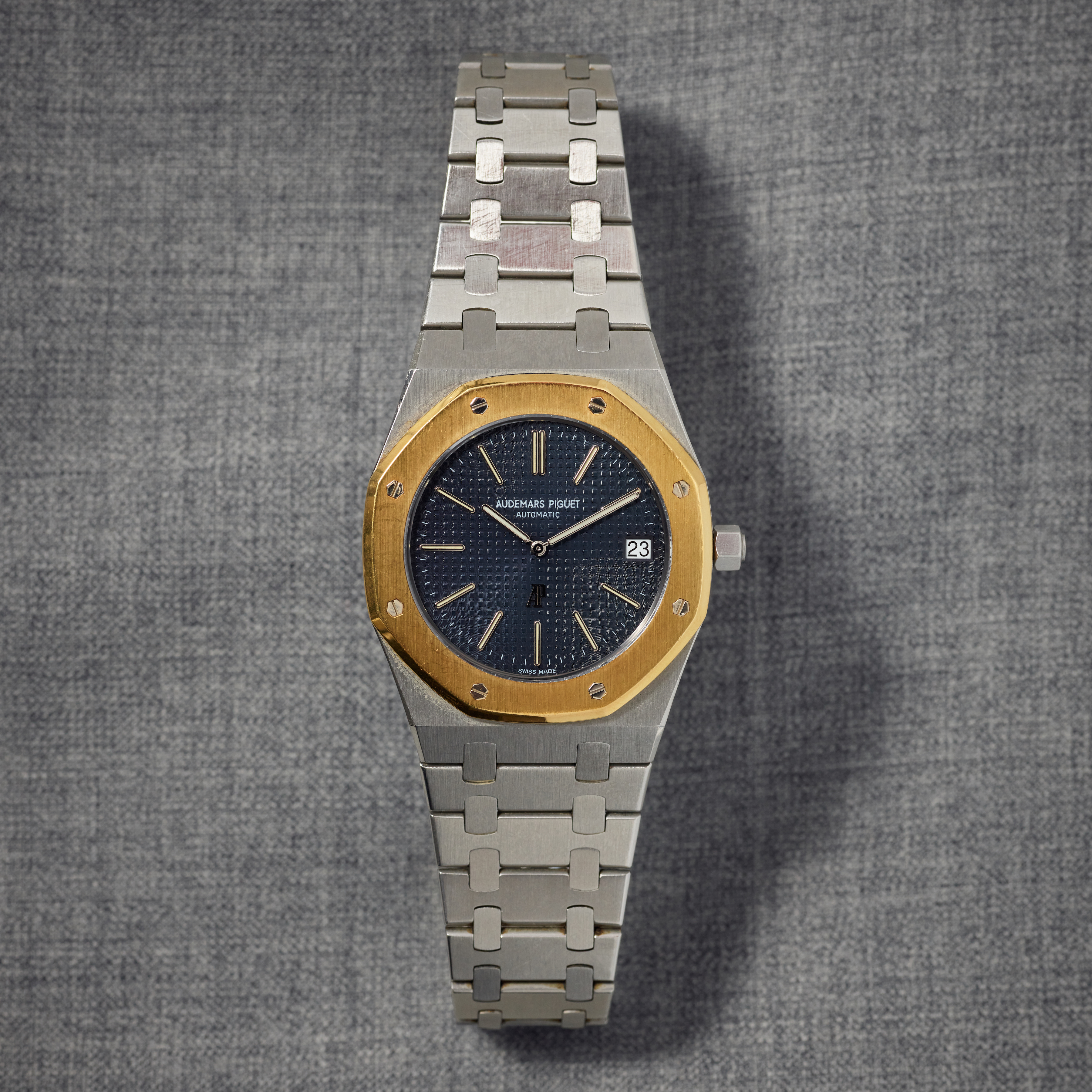 A two-tone Audemars Piguet Royal Oak 5402A laying on a grey background. 