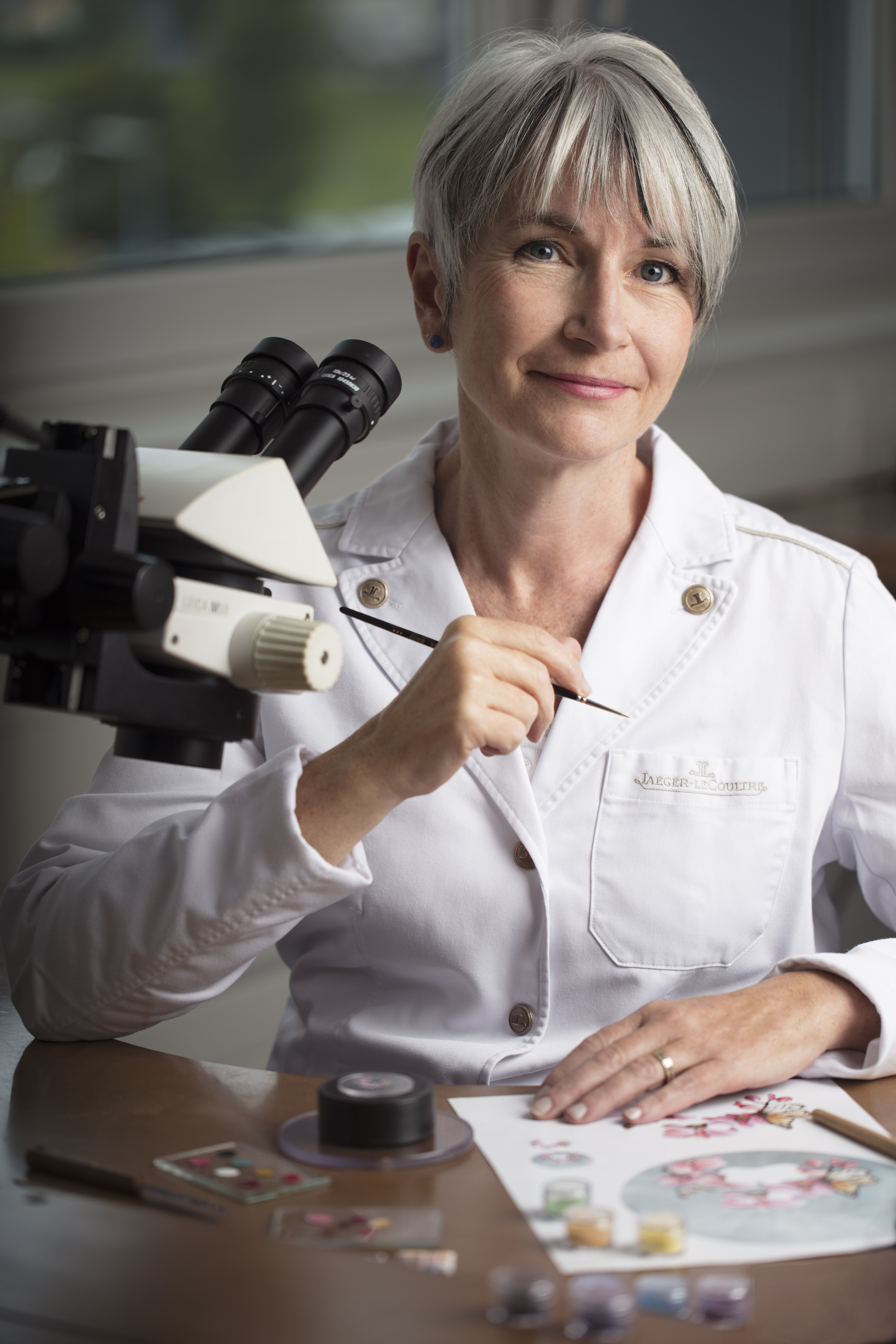 A woman at a desk with a microscope