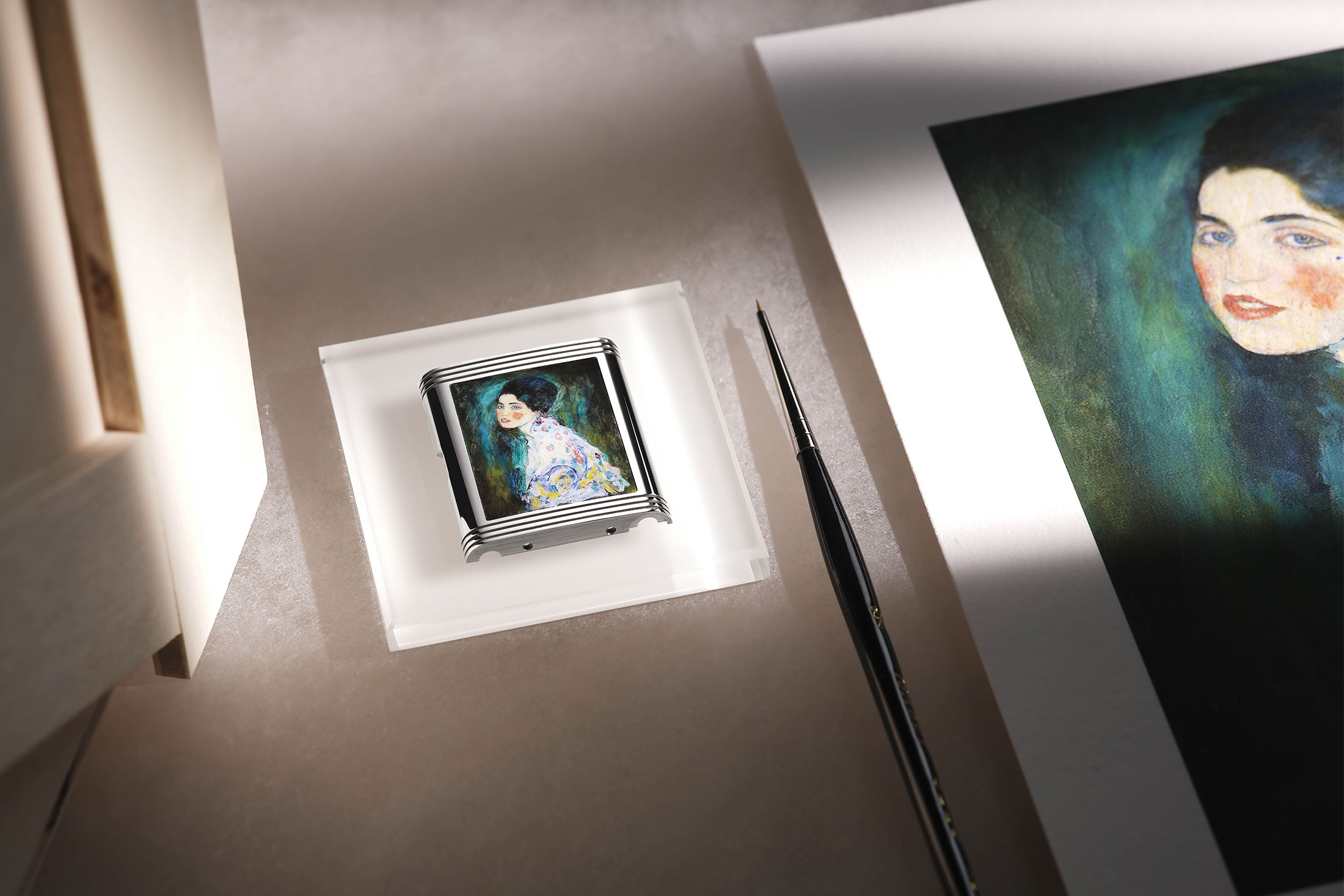 A watch case and large printing of a Gustav Klimpft painting