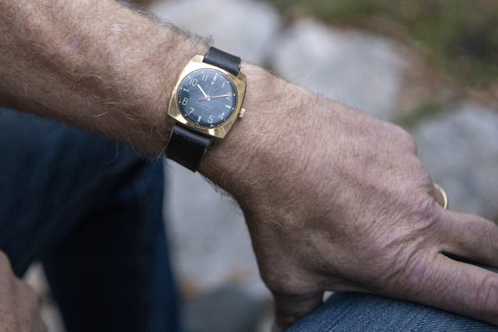A black dial watch on a wrist