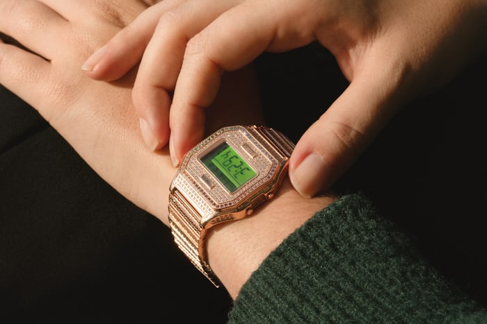 A person setting a Timex watch while wearing a sweater
