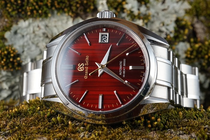 A Grand Seiko watch with a red dial. 