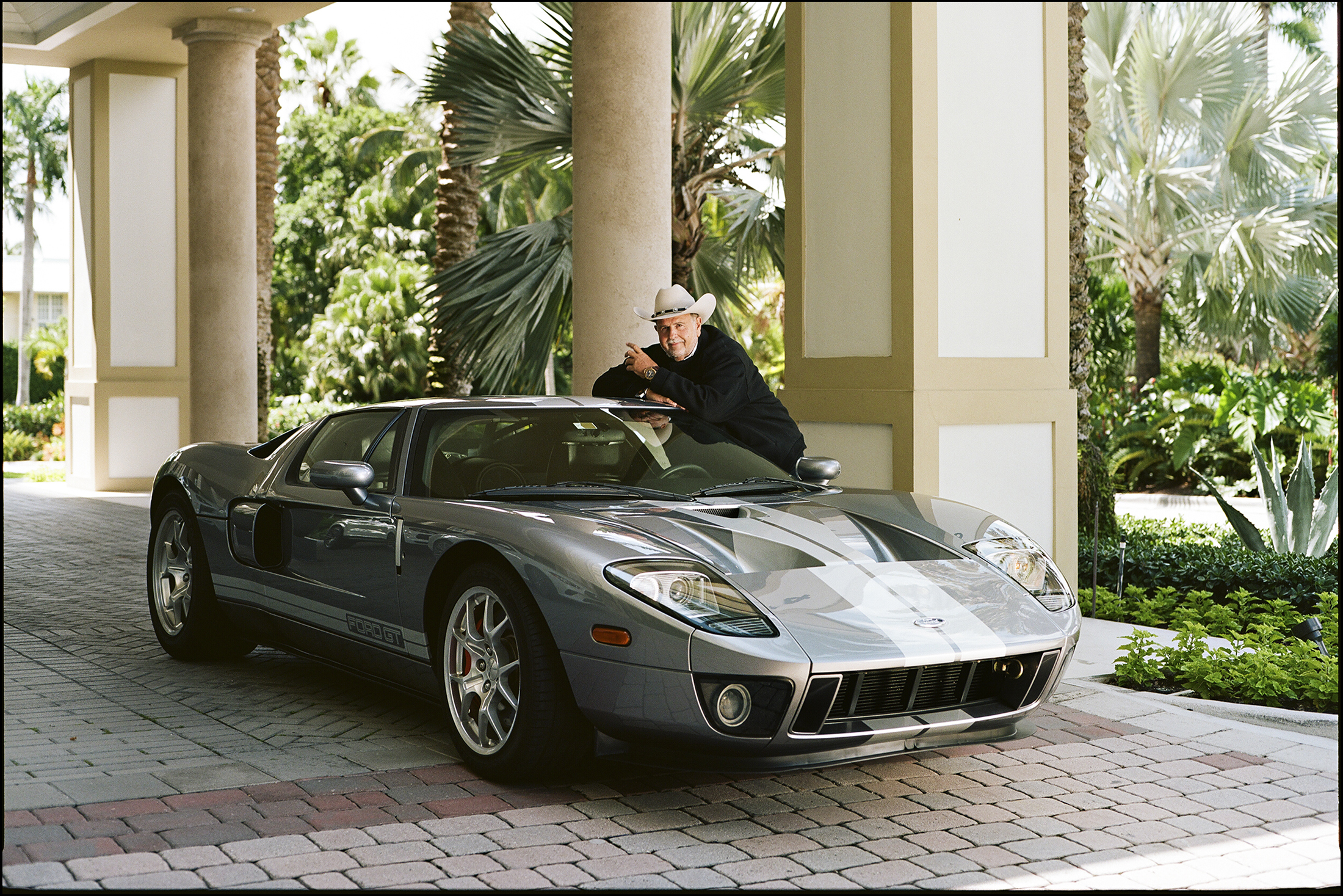 A man poses on his Ford GT40 car