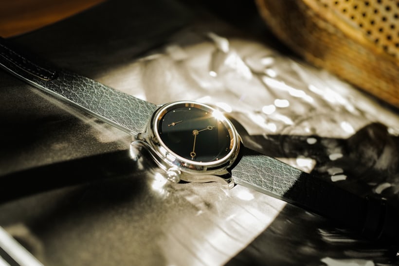 H. Moser x The Armoury Endeavour Small Seconds Total Eclipse flat lay reflecting in the sun