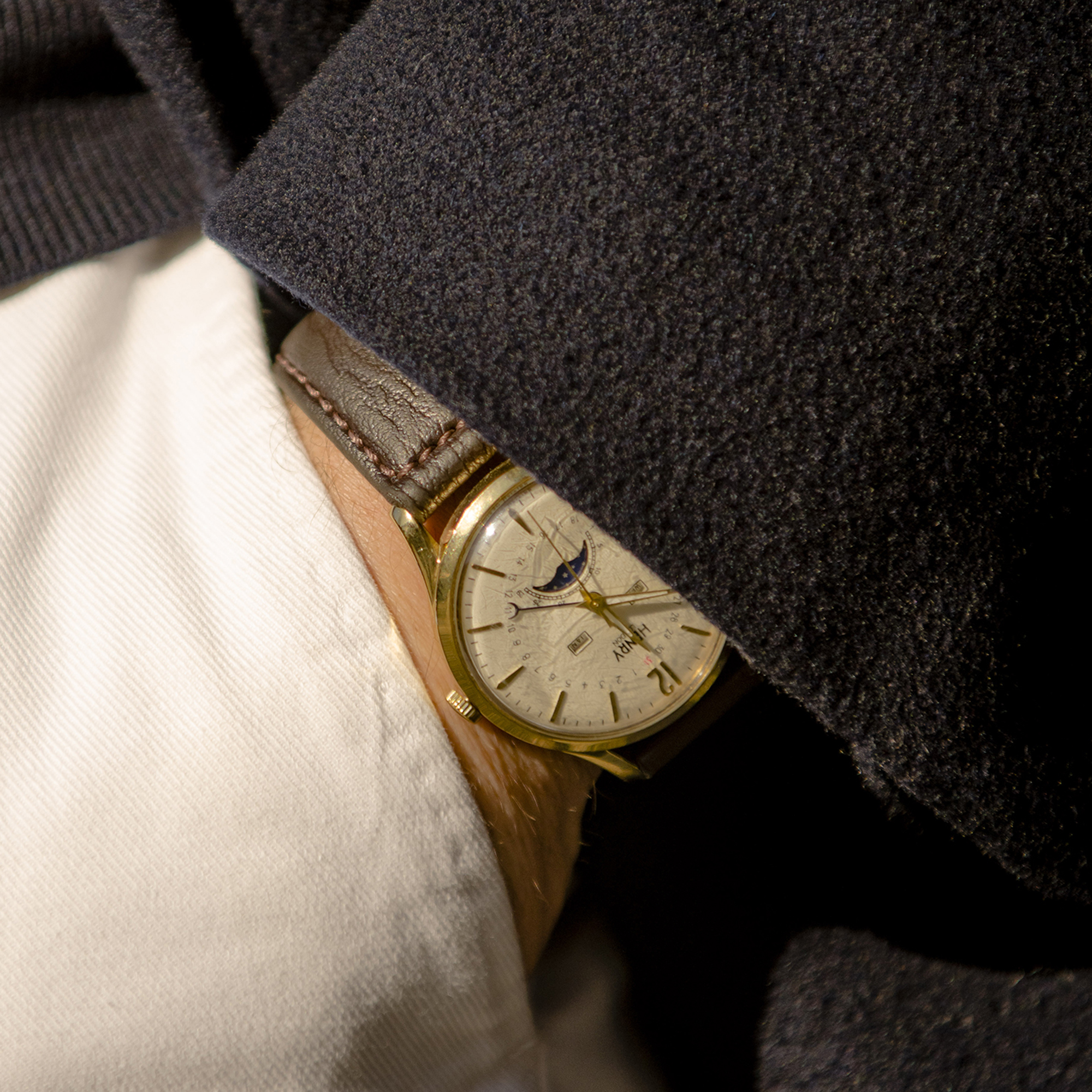 A white dial watch with a moonphase