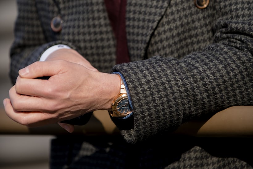 A watch sticking out from underneath a suit jacket