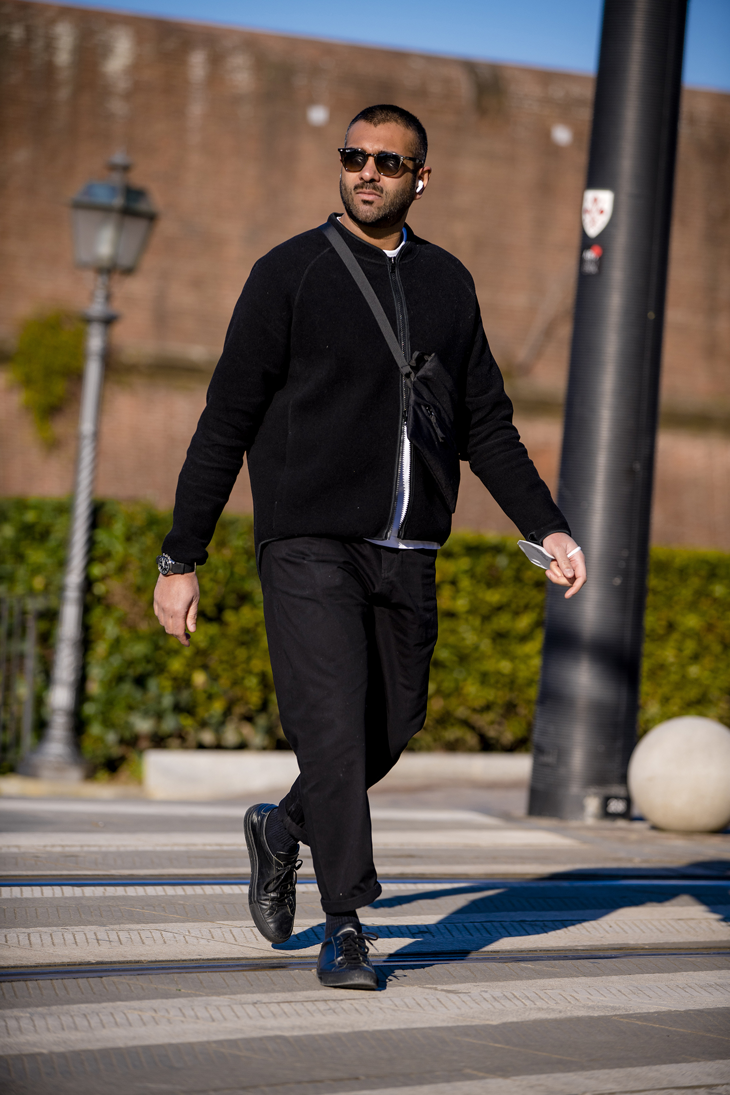 A man in all black walking outside