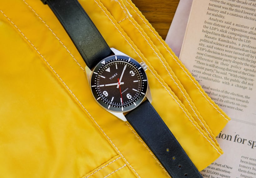 The Timex Waterbury HODINKEE Limited Edition rests on a yellow fabric background.