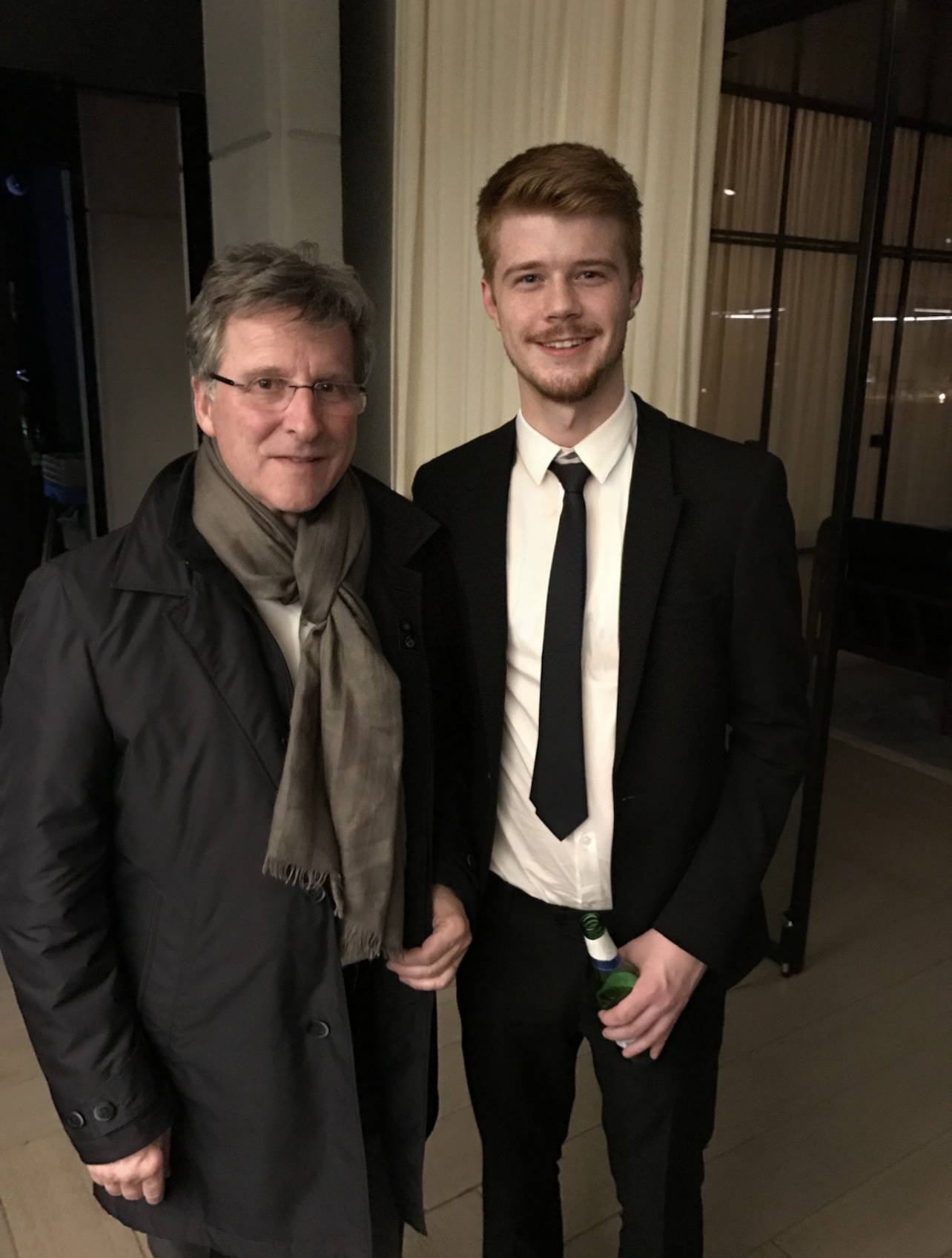 A young man stands next to Michel Parmigiani.