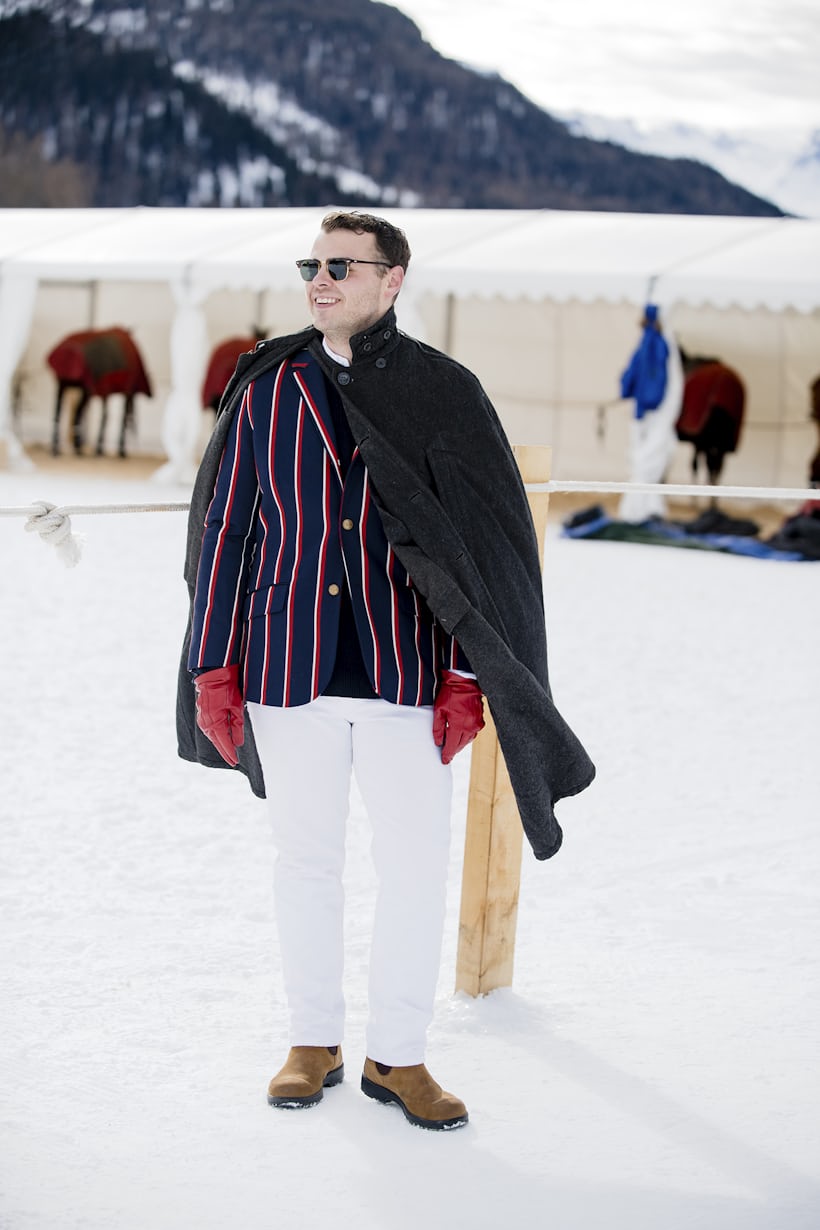 A man in a striped blazer stands in the snow