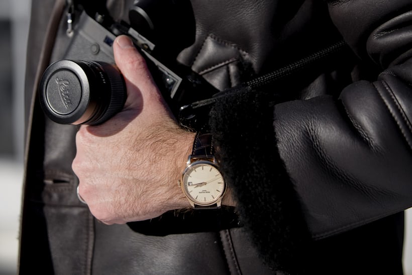 A person holding a camera and wearing a watch