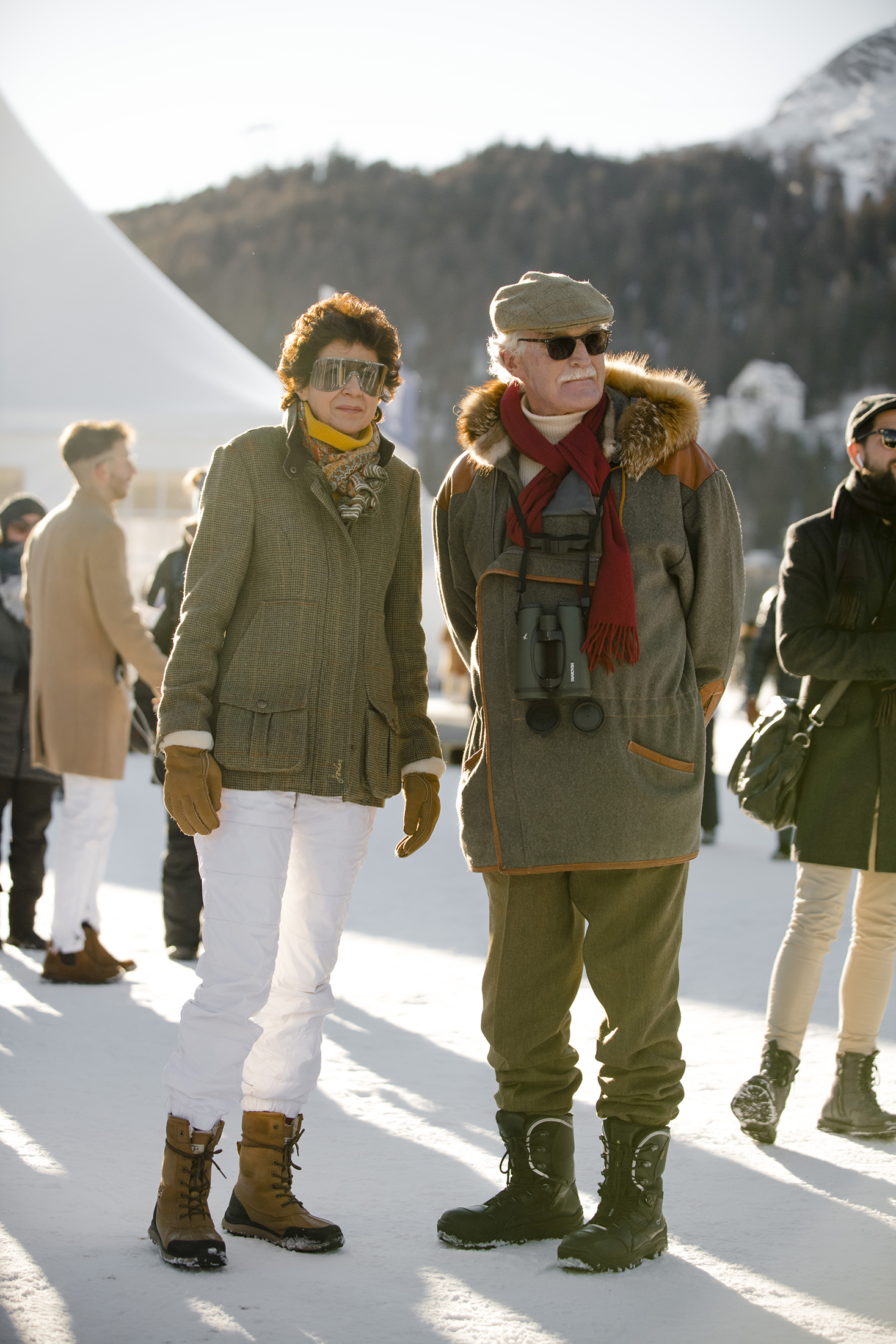 A pair of people in green coats 