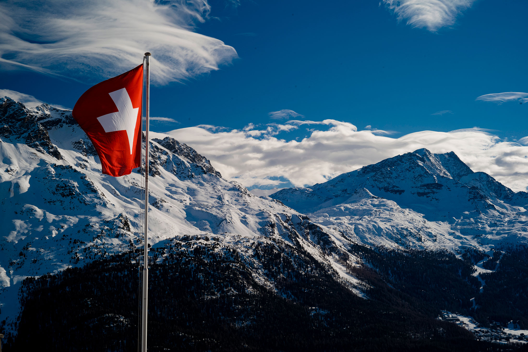 The Swiss flag in front of mountains