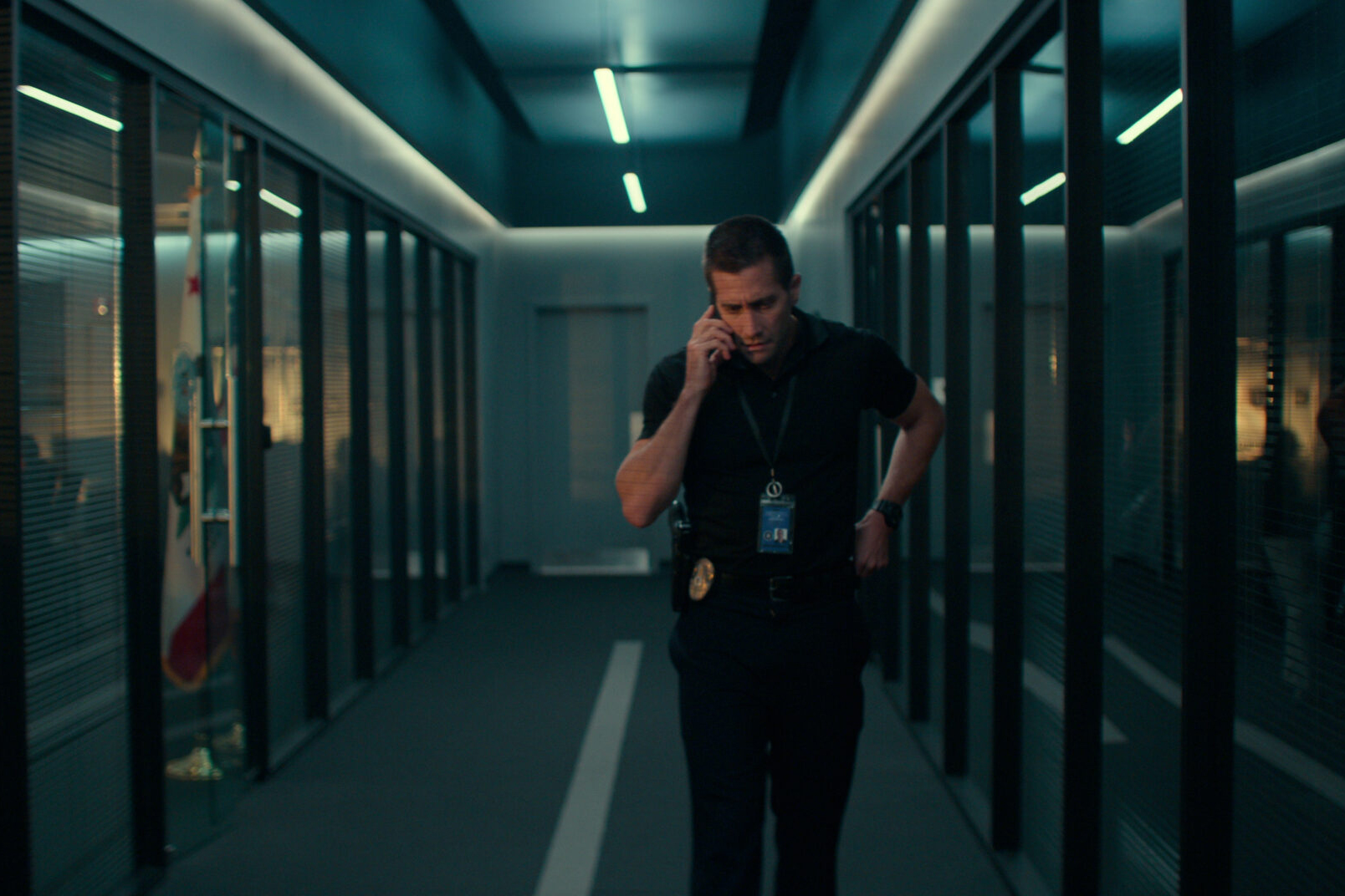 Baylor (Gyllenhaal) takes a personal call in the hallway with his G-Shock on his wrist in The Guilty. 
