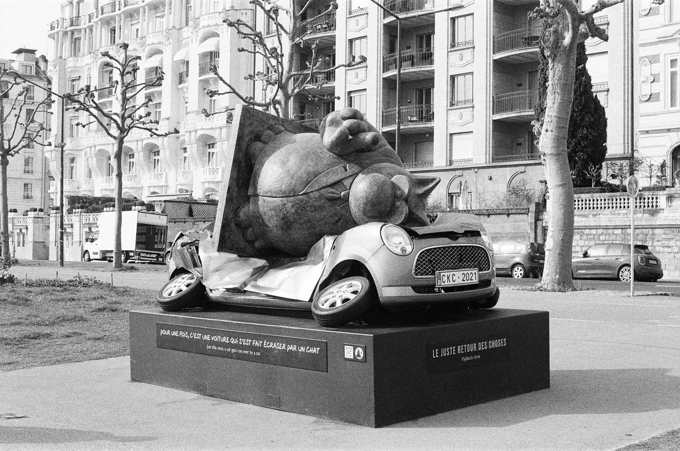 Statue of Geluck Cat pictured on top of mini cooper car statue.