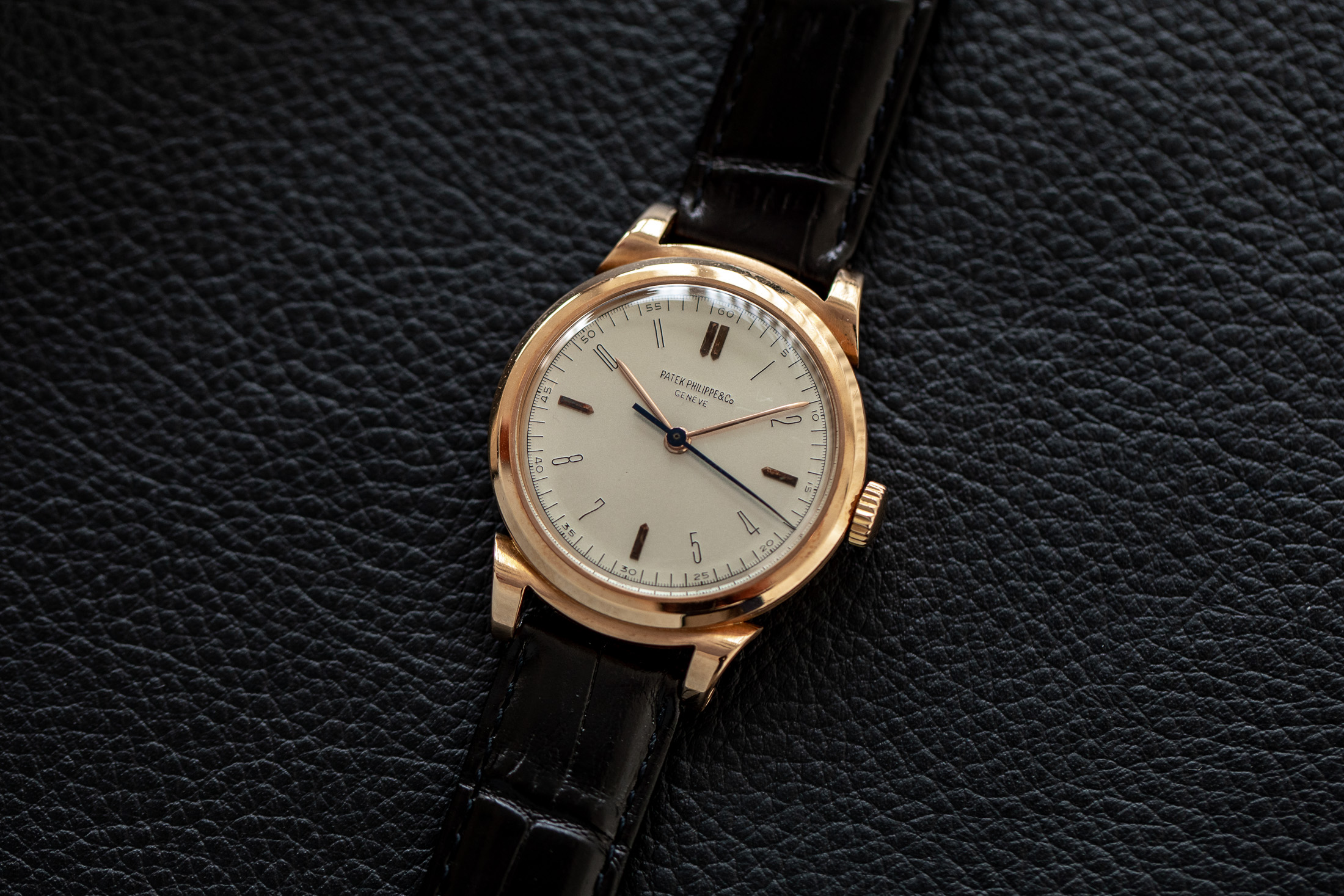 Patek Philippe Reference 1491 | A well preserved pink gold wristwatch with indirect centre seconds, hard enamel dial and scrolled lugs, Made in 1947