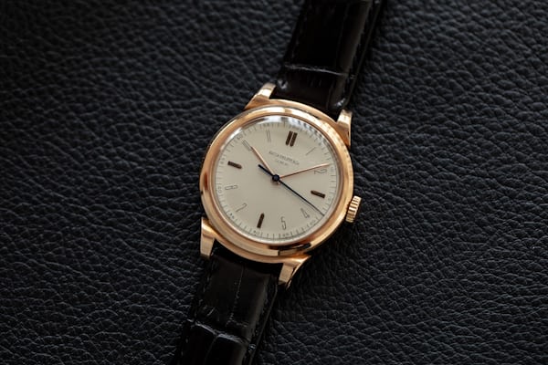 Patek Philippe Reference 1491 | A well preserved pink gold wristwatch with indirect centre seconds, hard enamel dial and scrolled lugs, Made in 1947