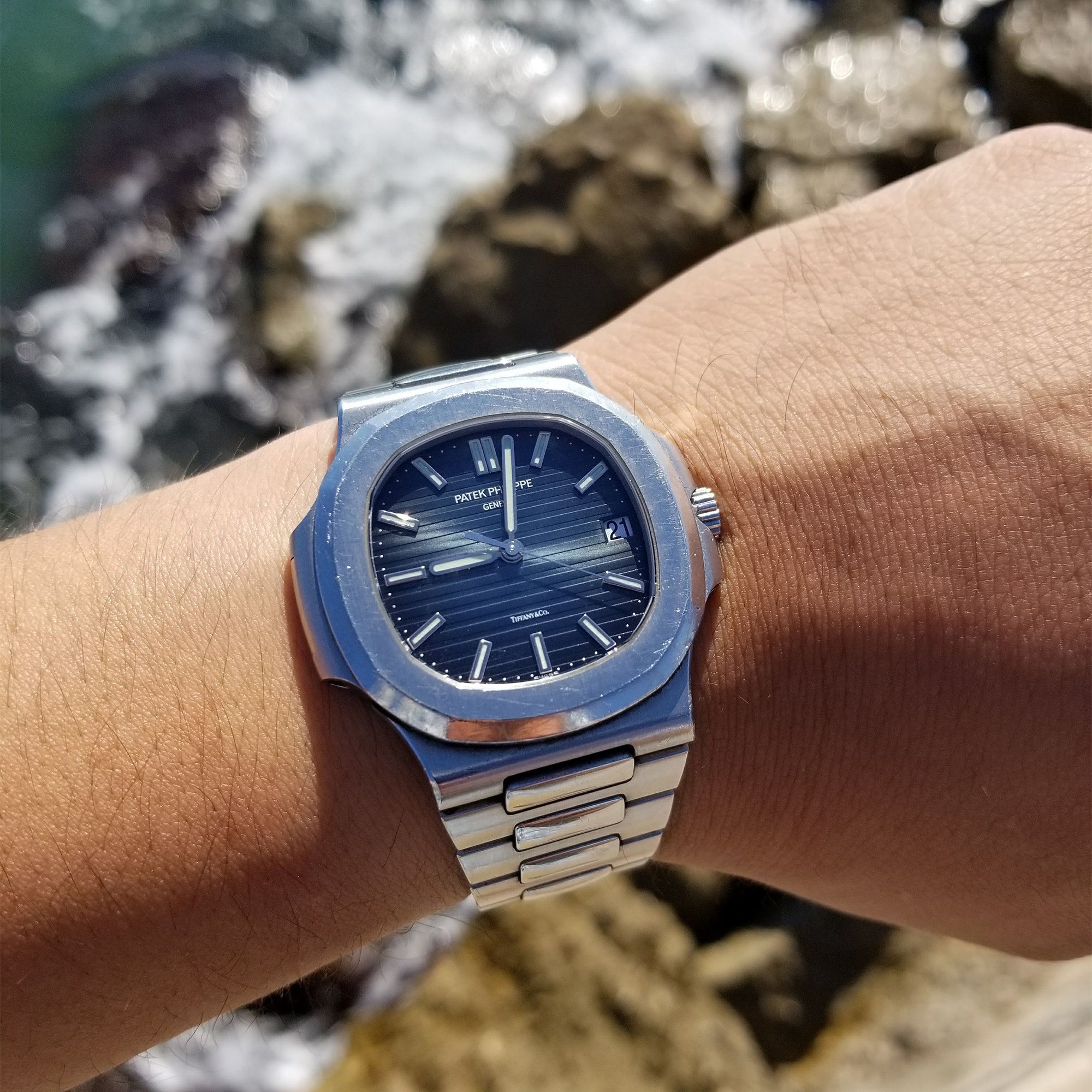 A man wears a Patek Philippe 5711 Nautilus with Tiffany stamp