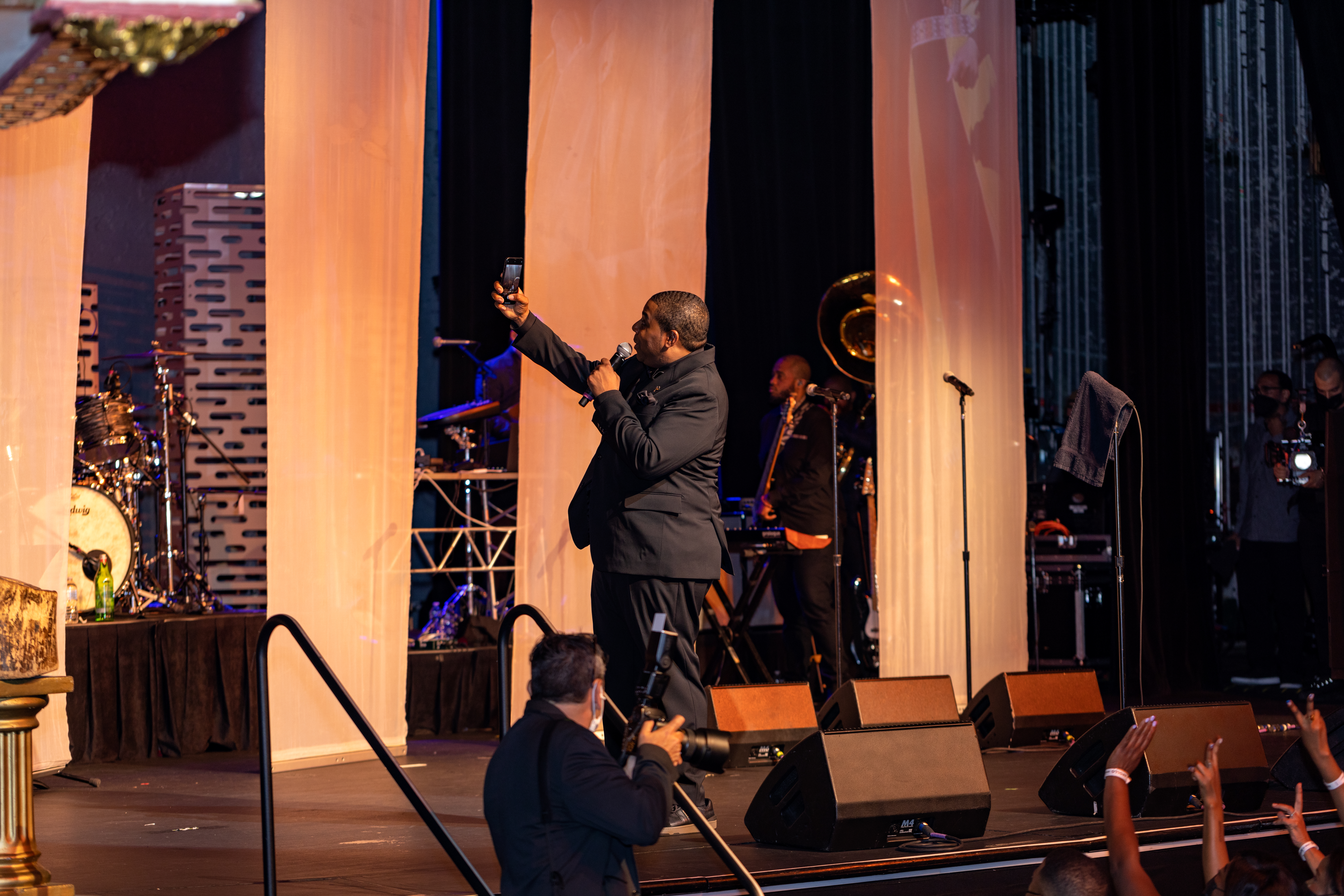a man takes a selfie from a stage 