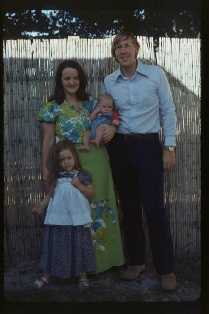 A family of four in front of a fence