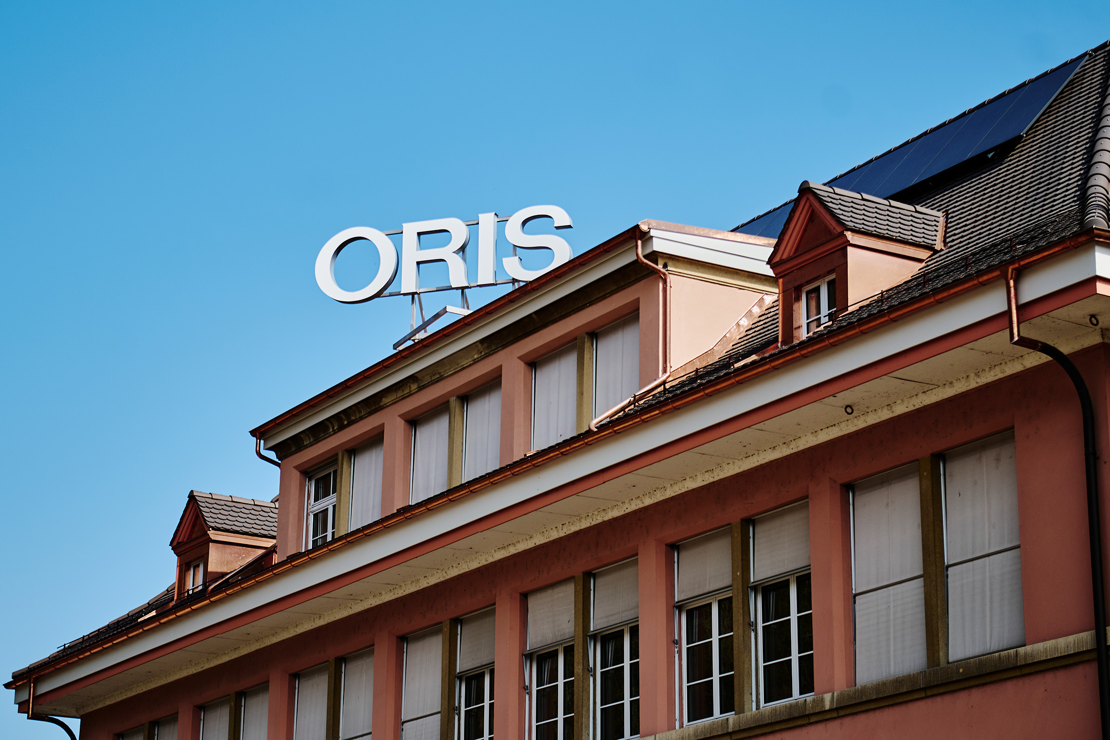 The Oris sign on the roof of their office building in the daylight
