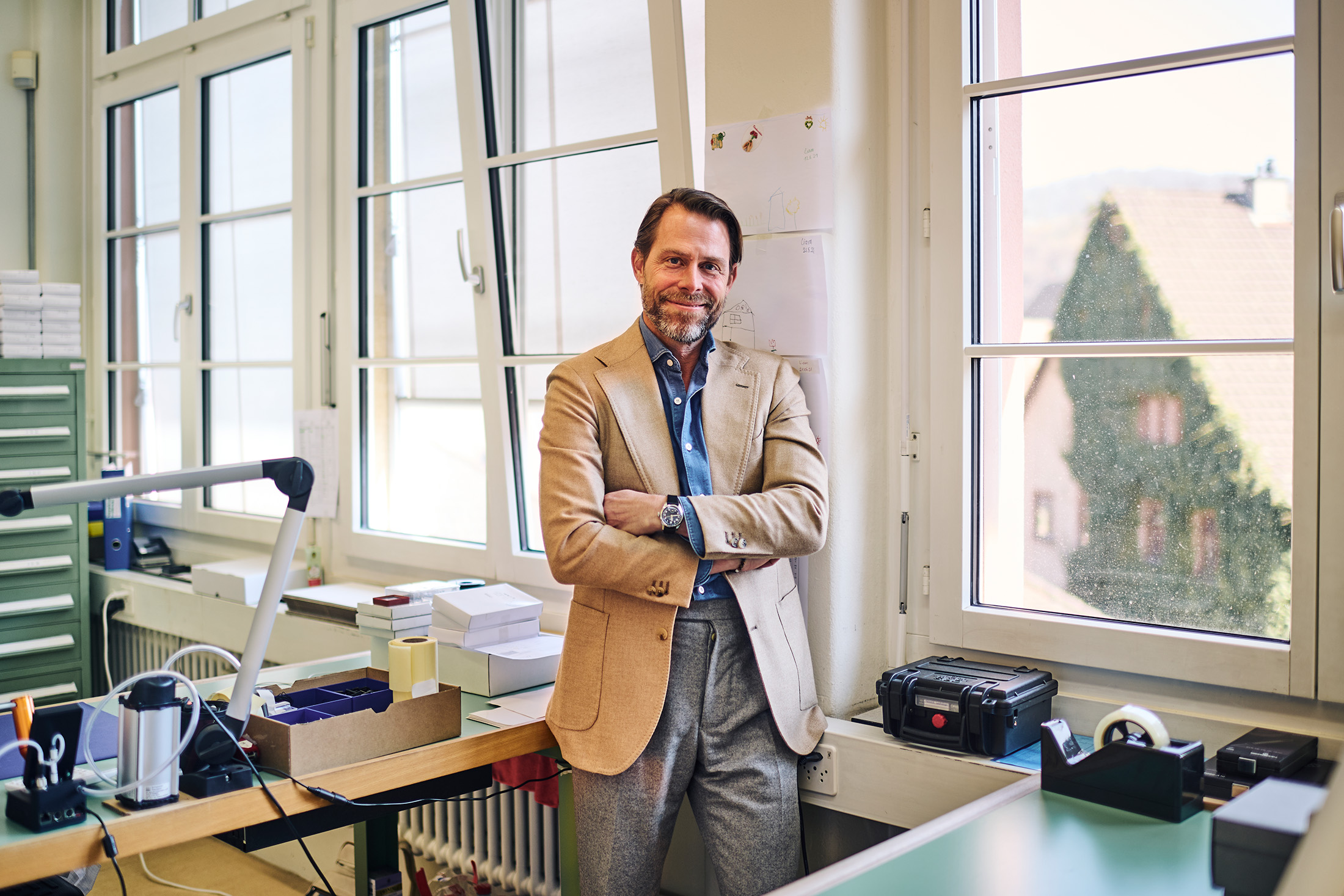 A man poses in a watchmaking studio